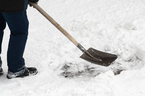 istock An unrecognizable worker is removing snow with an iron shovel with a wooden handle after a snowfall 2098517069