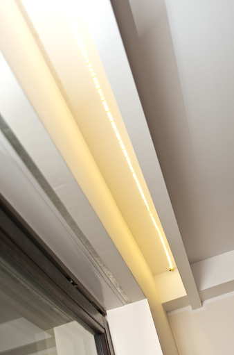 LED lighting in a ceiling recess, window illumination. Modern home interior