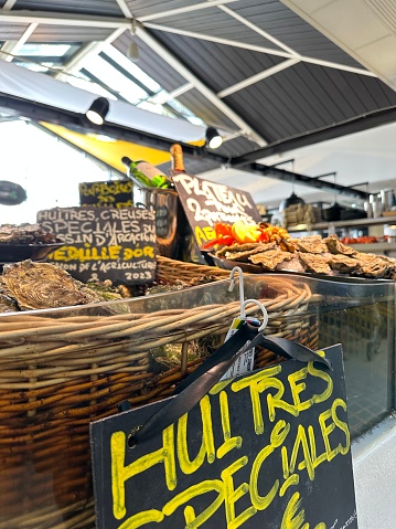 A colourful image of oysters in baskets on display at the indoor market hall of Arcachon, France.