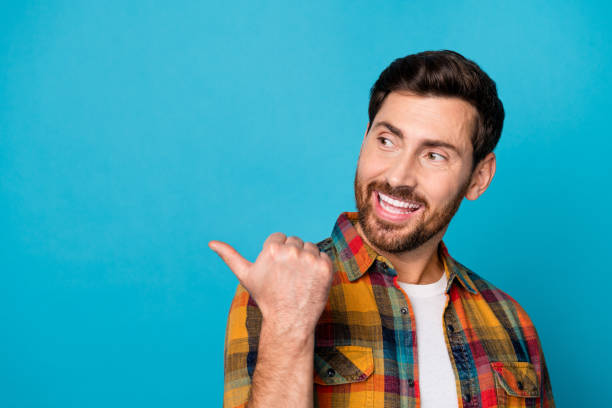 istock Photo of optimistic man with beard dressed checkered shirt look indicating at discount empty space isolated on blue color background 2098533771