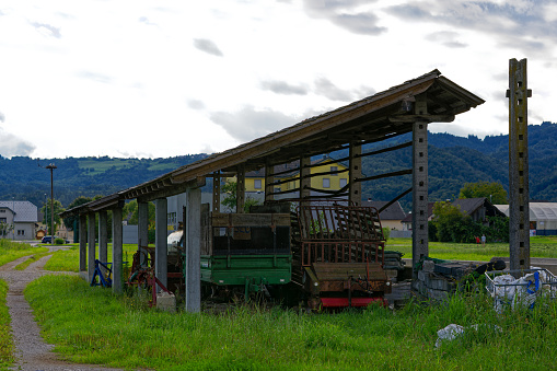 Scenic view of agriculture equipment at shelter at village of Zabnica on a blue cloudy summer evening. Photo taken August 10th, 2023, Zabnica, Kranj, Slovenia.