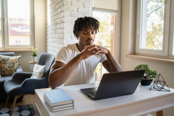 Man sat at desk looking at laptop screen