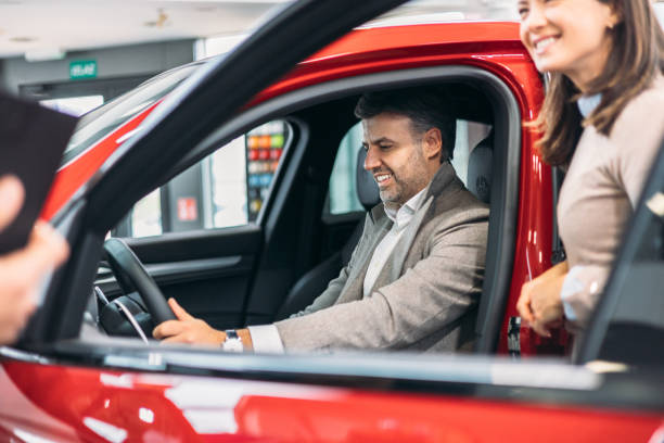 istock Couple trying new car with salesman explaining 2098563803
