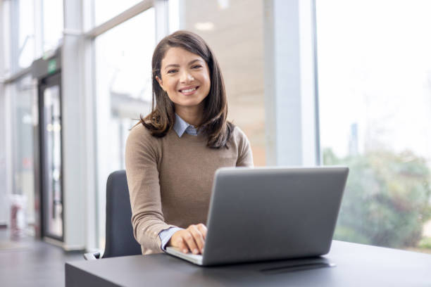 istock Smiling woman working on laptop in office 2098568996