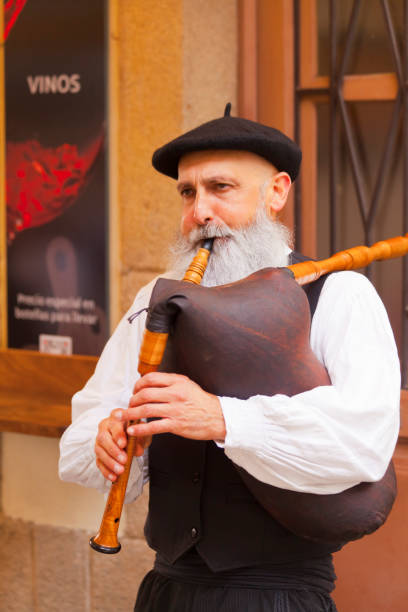 Lugo city, Spain_ October 9, 2022: Front view of senior piper playing, wearing historic clothes  during street performance. Lugo city, San Froilán annual celebrations, Galicia, Spain.