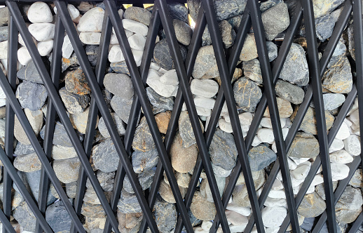 Stones wall in steel mesh wire cage texture and tree.\nmodern loft design.