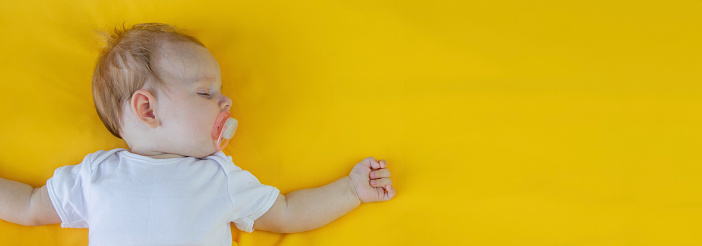 baby sleeps on a yellow background. child.