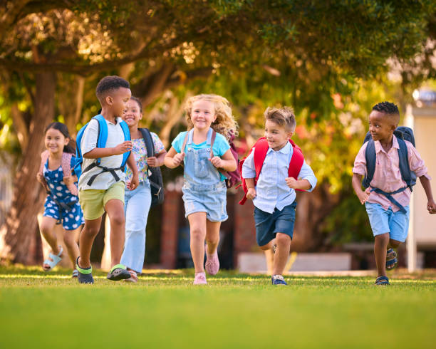 istock Multi-Cultural Primary Or Elementary School Students With Backpacks Running Outdoors At End Of Day 2098597701