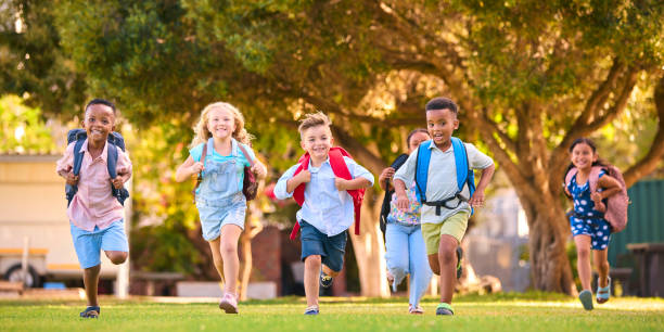 istock Multi-Cultural Primary Or Elementary School Students With Backpacks Running Outdoors At End Of Day 2098600298