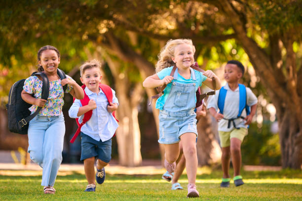 istock Multi-Cultural Primary Or Elementary School Students With Backpacks Running Outdoors At End Of Day 2098605154