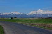 Bus on the road with a view of snow-covered mountains (view of Vysoke tratry-krivan)