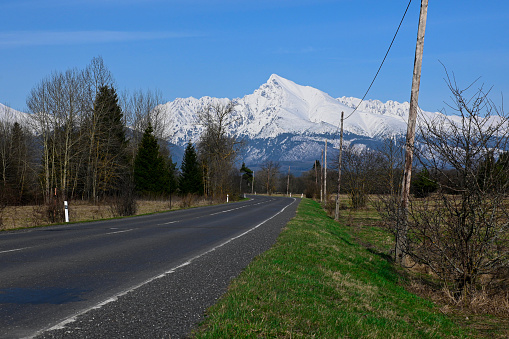 road with a view of the snow-covered mountains (High Tatras - Krivan).