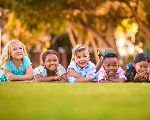istock Portrait Of Multi-Cultural Primary Or Elementary School Student Friends Lying On Grass Outdoors 2098620728
