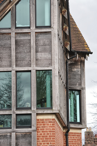 Cambridge, Cambridge, Cambridgeshire, England, United Kingdom, UK, Great Britain, Europe. March 18, 2024. Jerwood Library, Trinity Hall, a University library located at Cambridge CB2 1TJ, United Kingdom. Jerwood Library Trinity Hall River Cam in Cambridge.

The Jerwood Library Building, Architecture, Physical Structure, Facade. The image provides a view of the Jerwood Library at Trinity Hall, as seen from the Garret Hostel Bridge spanning the River Cam in Cambridge, England. The library building's distinct architecture, with its warm brick facade and large windows, stands out against the lush greenery along the riverbank. This picturesque scene captures the quintessential charm of the historic college campuses and their riverside settings in Cambridge, a city renowned for its world-class University of Cambridge and architectural heritage.