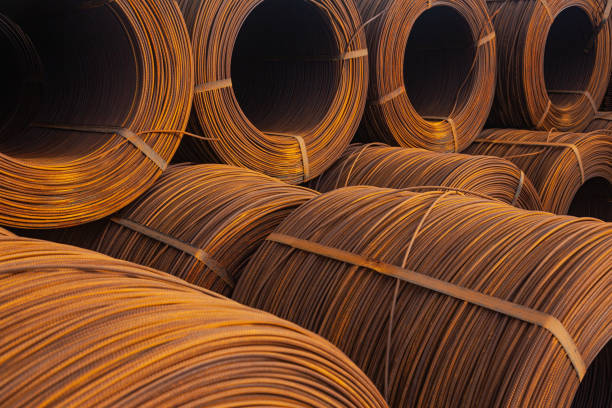 An open-air warehouse with twisted spools of rusty wire.