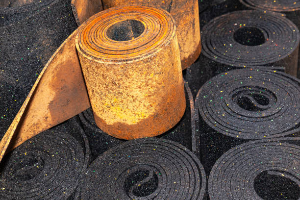 istock Old black sheet rubber and two rolls of brown rubber on top, rolled into rolls, top view. rubber waste. 2098669747