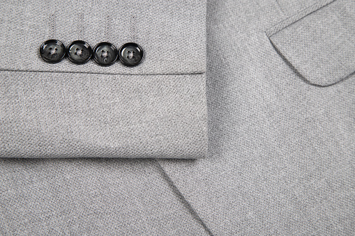 close-up of a classic grey wool coat with button