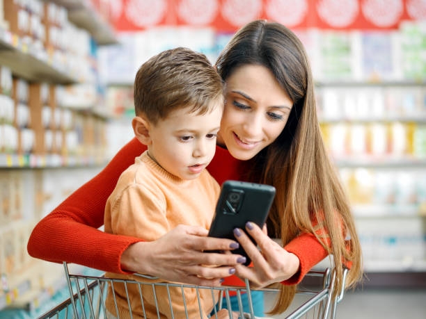istock Mother and son using a smartphone at the supermarket 2098702215