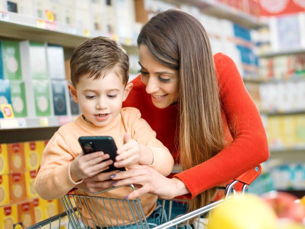 istock Mother and son using a smartphone at the supermarket 2098711862