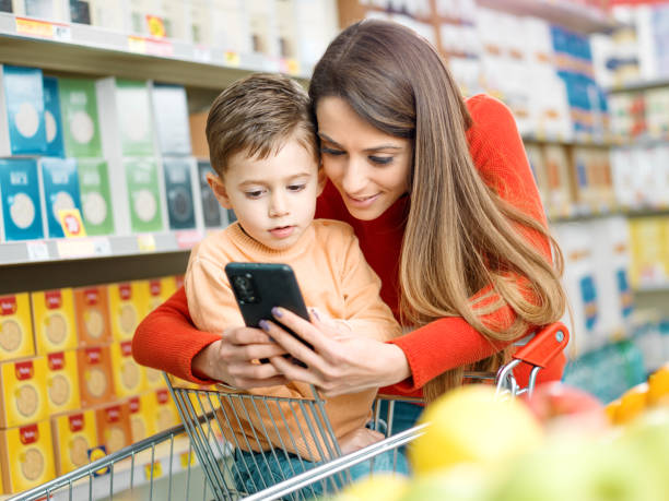 istock Mother and son using a smartphone at the supermarket 2098716130
