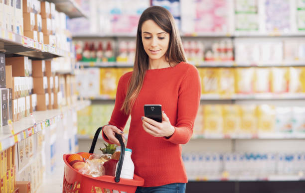 istock Young woman using her smartphone at the supermarket 2098721438