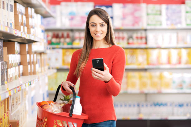istock Young woman using her smartphone at the supermarket 2098731632