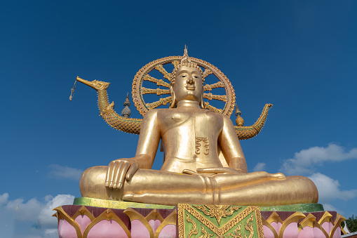 Golden buddha statue in the morning at Big Buddha Temple on Koh Samui island. Famous place for traveling. Religious arts and beliefs.