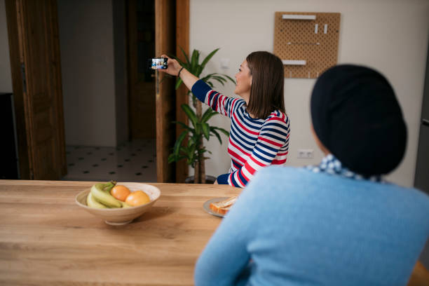 istock Two women using a phone to take a picture while having breakfast together 2098747492