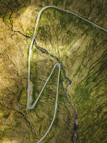 Drone shot over a highway going over a mountain pass. The N2 road goes over Sir Lowry's pass near Cape Town in South Africa. Large power lines run close to the highway