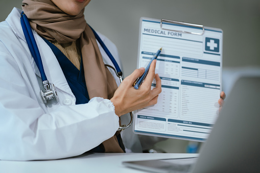 Pharmacist writing a medical diagnosis on paper in room clinic.