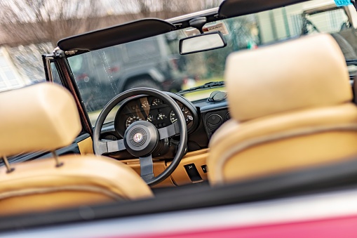 Vicenza, Italy 19 March 2024: Close-up photo featuring the vintage charm of an Alfa Romeo Duetto's steering wheel and dashboard.