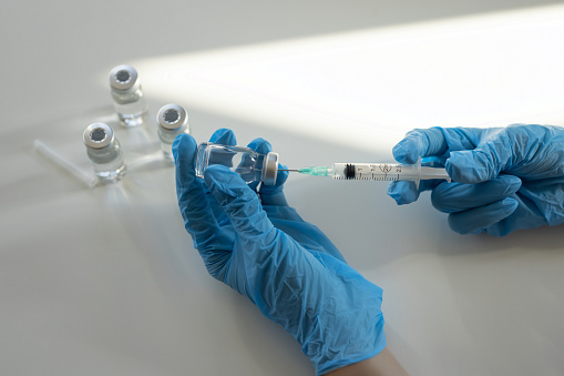 Medical person preparing to injection of medical vaccine or treatment.
