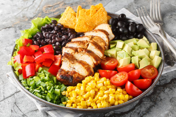 istock Tex-Mex Santa Fe chicken salad with lettuce, tomatoes, corn, black beans, pepper, avocado, olive closeup on the plate. Horizontal 2098846302