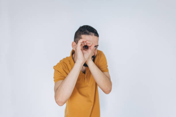 Man pretending to look on telescope on white background