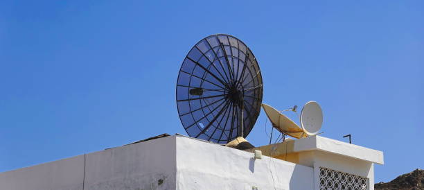 istock Communication Contrast: Satellite Dishes Against Clear Sky, Modern Technology On Traditional Rooftop 2098875126