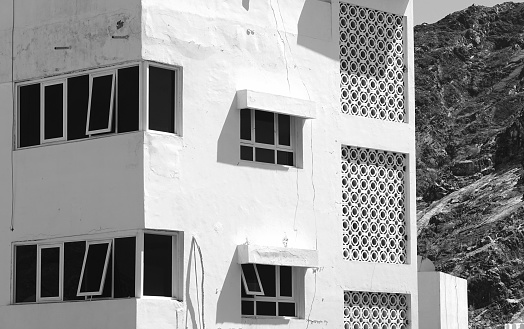 Architectural Harmony: Geometric Patterns And Crisp Edges, Monochrome Facade Against Rugged Mountain