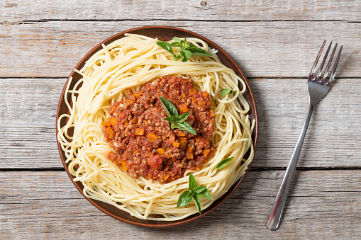 Traditional Italian pasta bolognese . Top view on wooden background