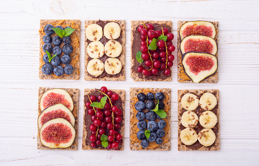 Protein toast crispbread with delicious toppings top view : figs , banana ,  blueberry , red currant . Superfood
