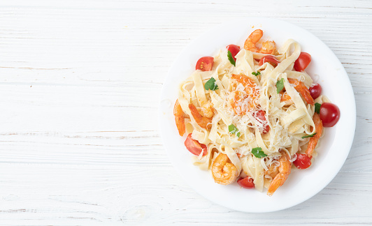 Italian pasta with shrimps , parmesan and tomatoes. Fettuccine in a creamy sauce top view