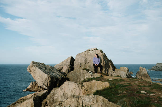 istock Young woman leaning on a rock 2098912232