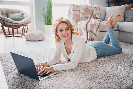 Full size profile photo of creative gorgeous girl barefoot laying floor use laptop brainstorming coworking bright house inside.