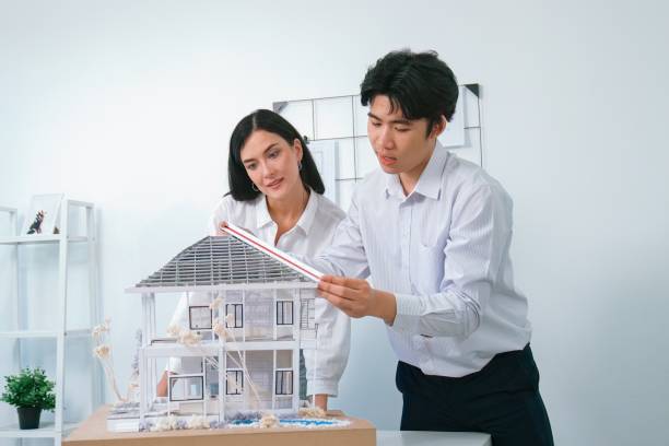 istock Cooperative engineer team working together to measure house model. Immaculate.. 2098922646