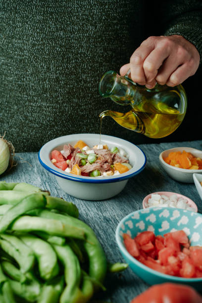 istock man dressing a broad bean salad with olive oil 2098941772