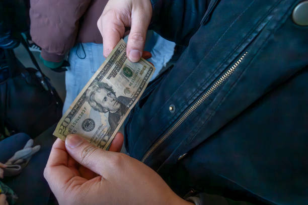 мужчина держит двадцатидолларовую купюру сша - twenty dollar bill human hand paper currency number 20 стоковые фото и изображения