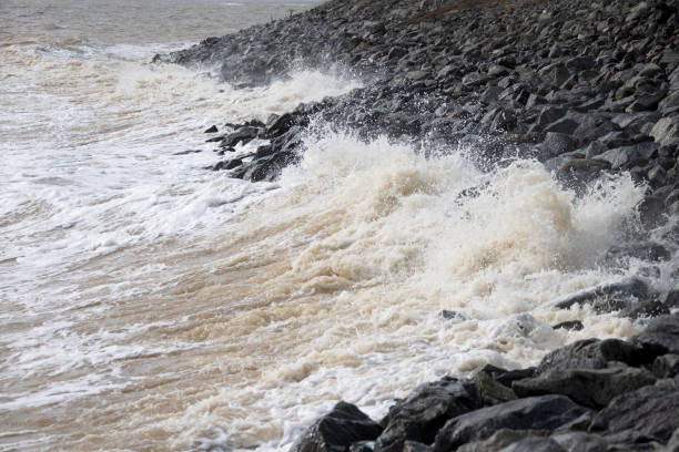 Las olas rompen contra las piedras de granito durante una tormenta en la costa del Mar Negro. Terrapel de la ciudad en un día nublado de invierno en Odessa - foto de stock