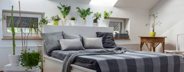 istock Home interior with window and cosy bedroom in the attic in boho style with comfortable bed and grey pillow. Interior decor. Panoramic. 2099030564