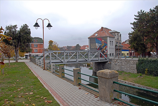 View on - Iron Bridge in the city - Knjazevac, Serbia. This bridge, which used to be made of wood, is located on the square - Dimitrija Tucovica. On the other side of the bridge, is a Mural on the house, dedicated to the Grand Duke of Serbia - Milos Obrenovic, whose name of this city. The photo was taken - 11.11.2021 at 12:27:34 local time.