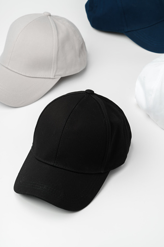 hats, of varying styles and colors, are neatly arranged on top of a white table.