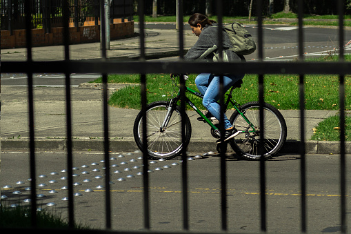 Bogota Colombia 21 de Febrero de 2024:Cycling freedom: woman on a bicycle behind bars