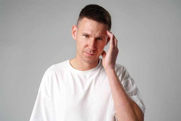 istock Young handsome man standing over gray background suffering from headache 2099056102